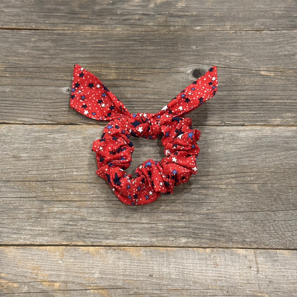 Red scrunchie with white polka dots on a wooden surface