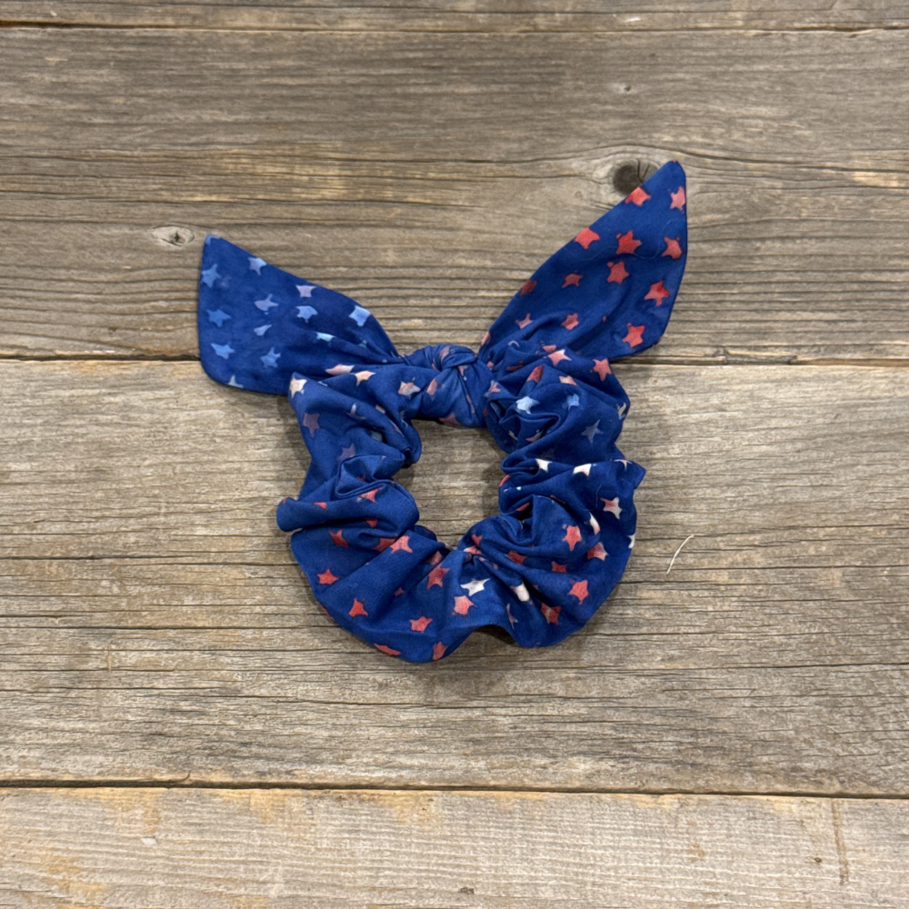 Blue scrunchie with red and white pattern on a wooden surface