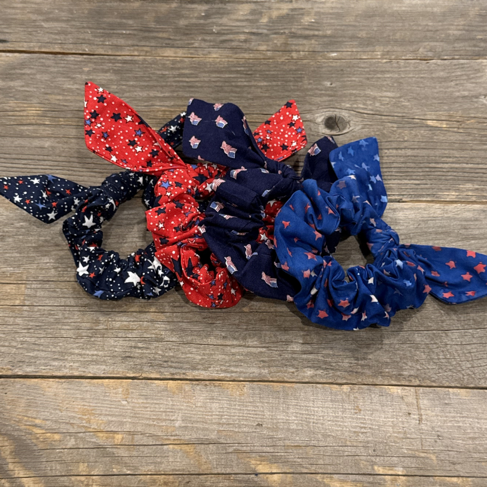 Set of red, white, and blue hair scrunchies on a wooden surface